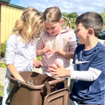 students examining shredded paper compost